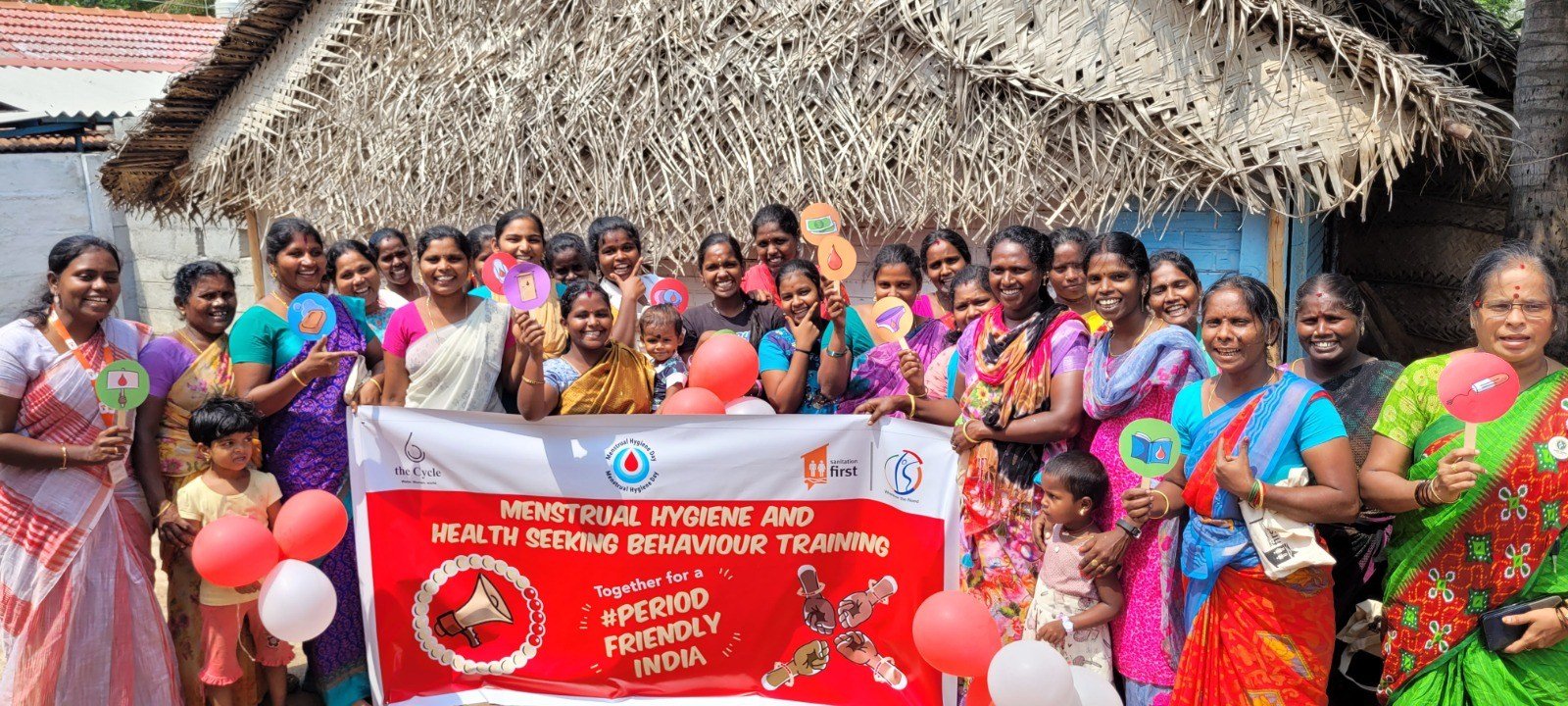 Women joyfully display symbols of creating a period friendly world